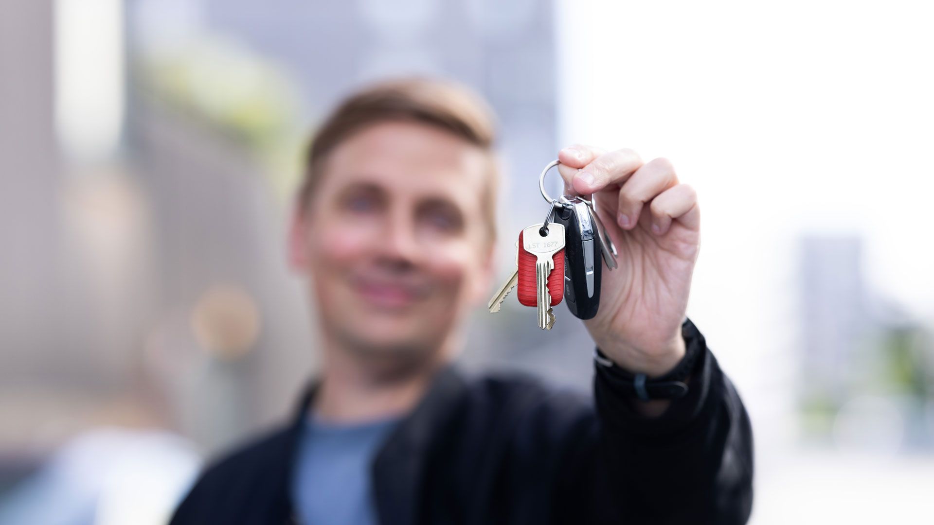 Mann holder nøkkelknippe foran kamera